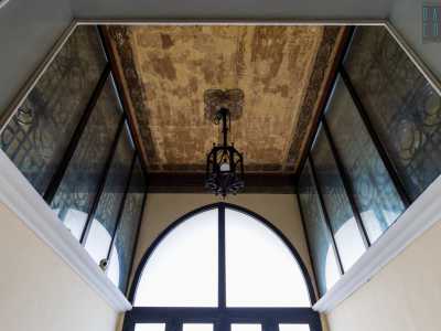 Nel vano di ingresso, alzando lo sguardo, ne notiamo subito uno ligneo, da cui pende un elegante lampadario in ferro
